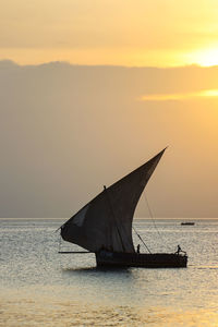 Sailboat on sea against sky during sunset