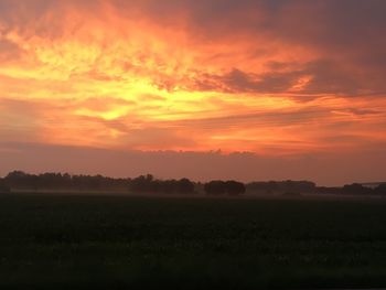 Scenic view of silhouette landscape against orange sky