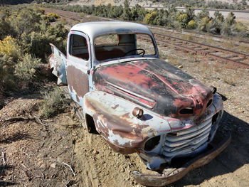 Old abandoned car on field