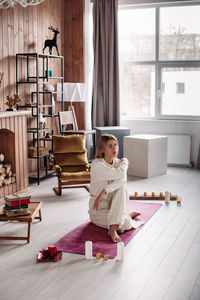 Woman sitting on wooden floor at home