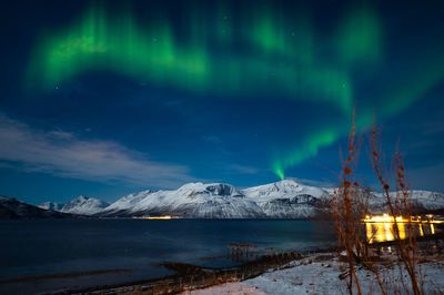 Northern lights covered on the snowy mountains in the arctic area of norway