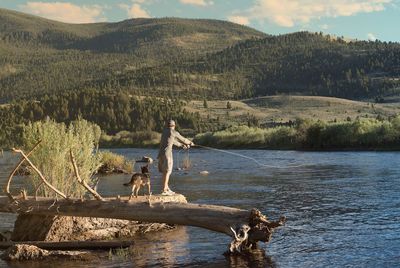 Rear view of a man fishing on lake