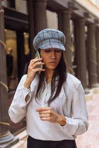 Full length of woman wearing hat standing outdoors