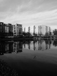 Reflection of city in water against sky