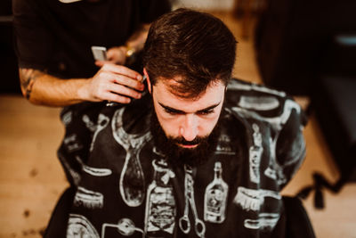 Cropped hands of barber grooming customer in salon