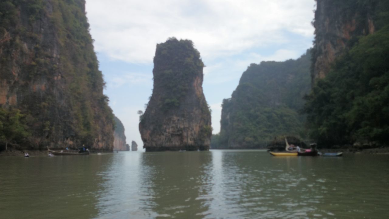 water, mountain, nautical vessel, sky, scenics, tranquility, boat, tranquil scene, beauty in nature, transportation, rock formation, waterfront, nature, mode of transport, tree, rock - object, sea, cliff, travel, lake