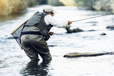 Side view of a man fishing in river
