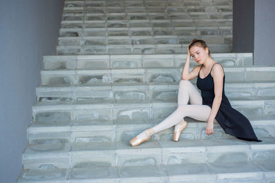 Portrait of woman sitting on staircase