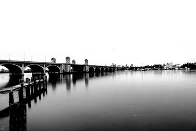 Bridge over calm sea against clear sky