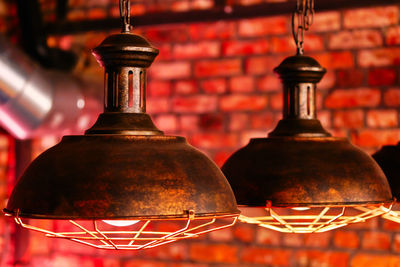 Close-up of illuminated lamp against wall