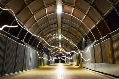 Illuminated light painting on footbridge at night