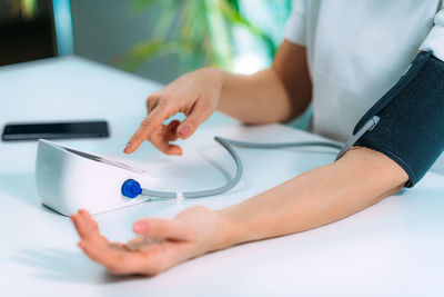 Woman measuring blood pressure at home