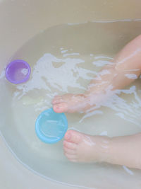 Low section of person with ice cream in water