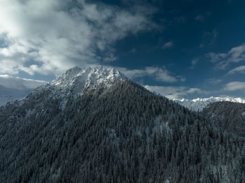 Mountain peak view in winter blue sky and clouds