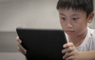Close-up of boy holding digital tablet