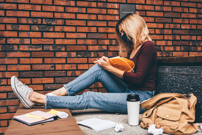 Young woman using laptop while sitting on sofa at home