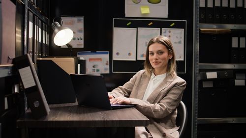 Portrait of young woman using laptop at home