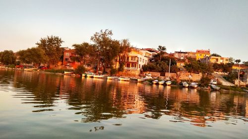 Scenic view of river by buildings against clear sky