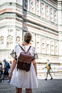 Rear view of woman standing on street in city