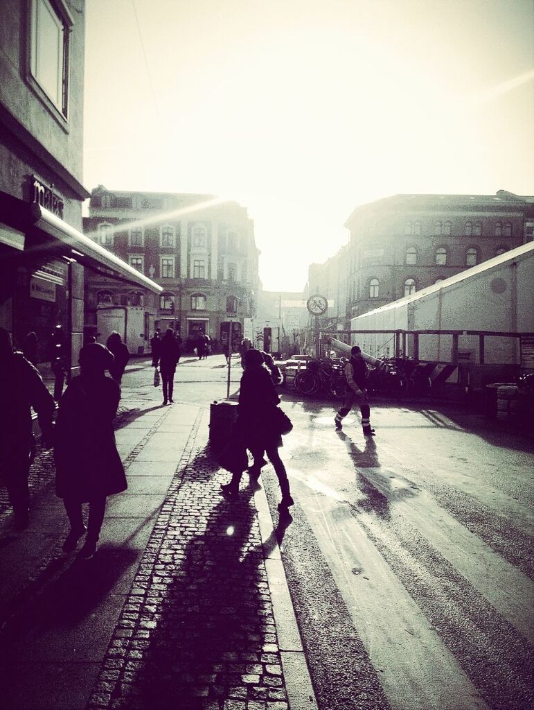 architecture, building exterior, built structure, walking, city, street, transportation, men, lifestyles, city life, person, full length, land vehicle, city street, mode of transport, bicycle, large group of people, sunlight, road