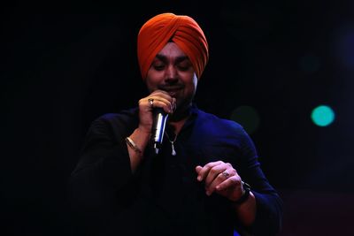 Low angle view of singer singing against black background