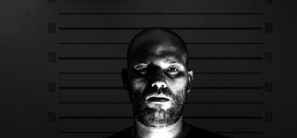 Close-up portrait of man standing wall with numbers