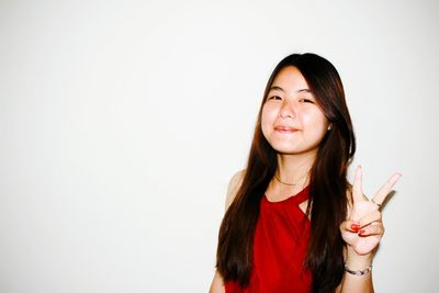 Portrait of smiling young woman against white background