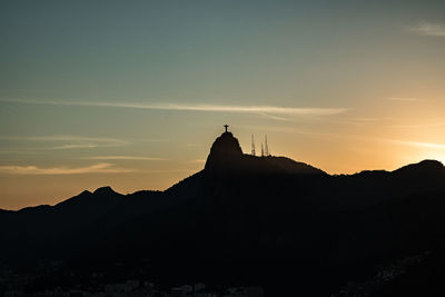 Distant view of christ the redeemer against sky during sunset