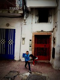 Boy playing in front of building