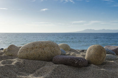 Rocks on beach against sky