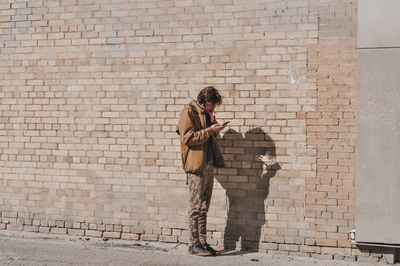 Full length of man playing on brick wall