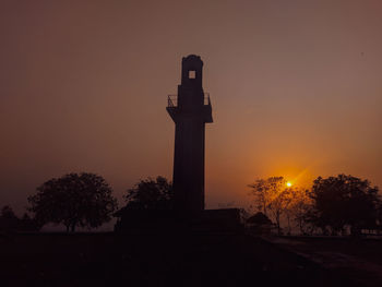 Lighthouse against sky during sunset