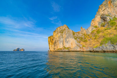 Rock formations in sea against blue sky