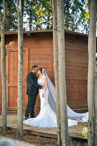Wedding couple kissing while standing by built structure