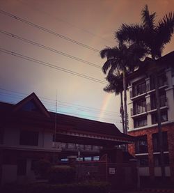 Houses against sky at sunset