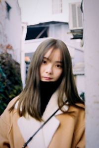 Portrait of beautiful woman standing against wall