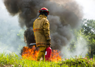 Rear view of man walking by fire