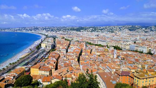 High angle view of town by sea against sky