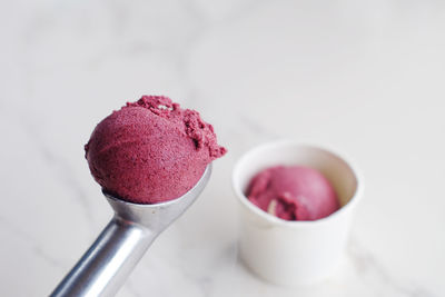 Close-up of ice cream on scoop over table