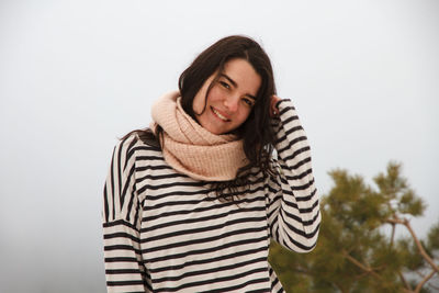 Portrait of young woman wearing striped top during foggy weather