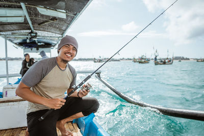 Portrait of young man standing in boat