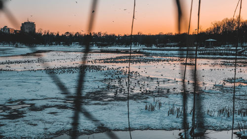 Scenic view of frozen lake against sky during sunset