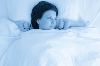 High angle view of young woman sleeping on bed