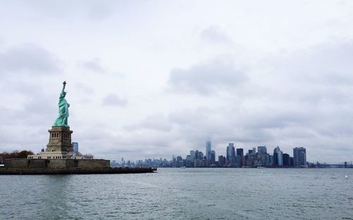 Silhouette of statue of liberty against cloudy sky