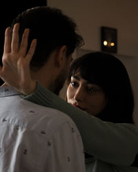 Close-up of young woman looking away at home