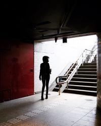 Full length rear view of man walking on building