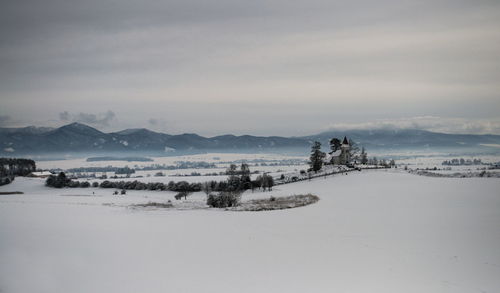 Scenic view of snow covered land against sky