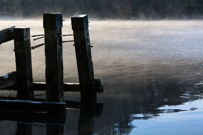 Wooden posts on pier over lake