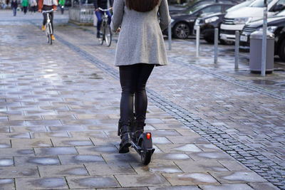 Electric scooter or e-scooter on busy city sidewalk shared with bicycles and pedestrians