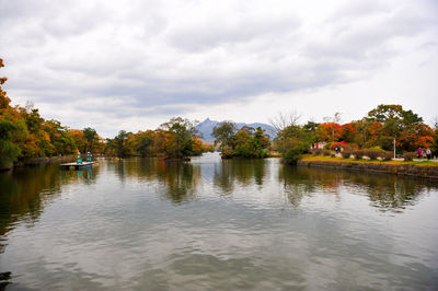 Scenic view of calm lake against cloudy sky